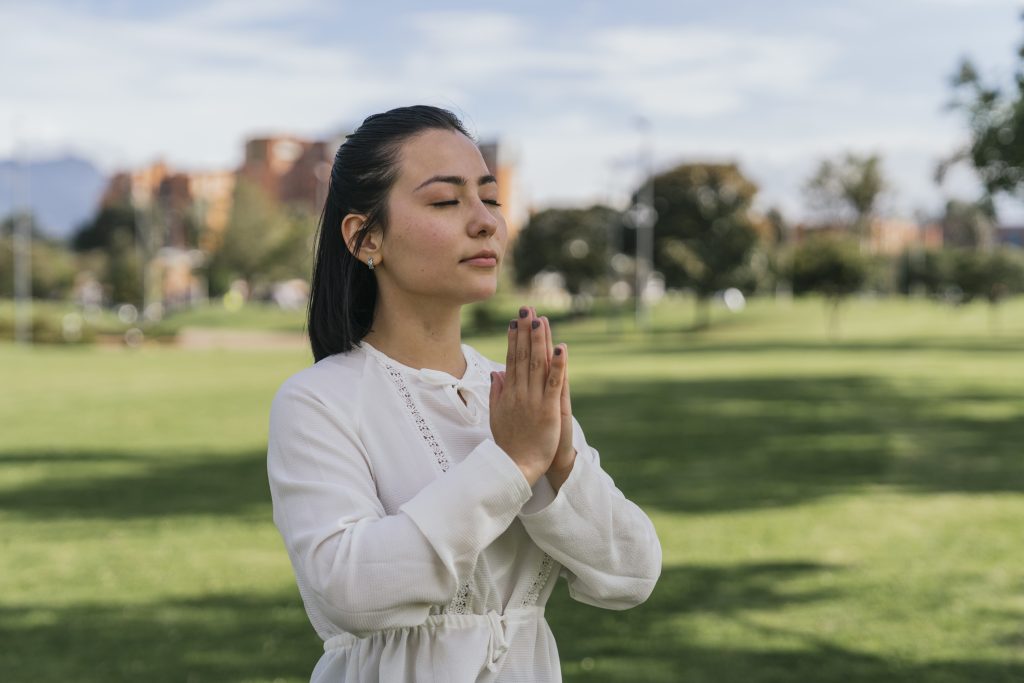 hispanic female doing yoga at a park