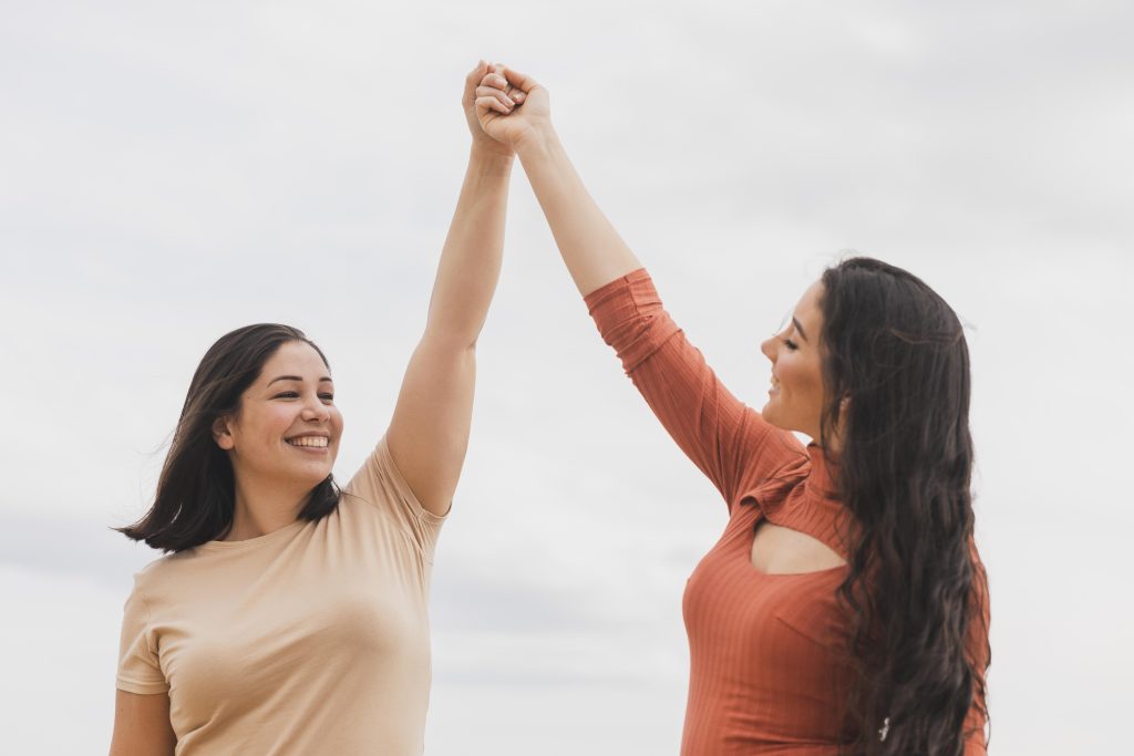 low angle women holding hands